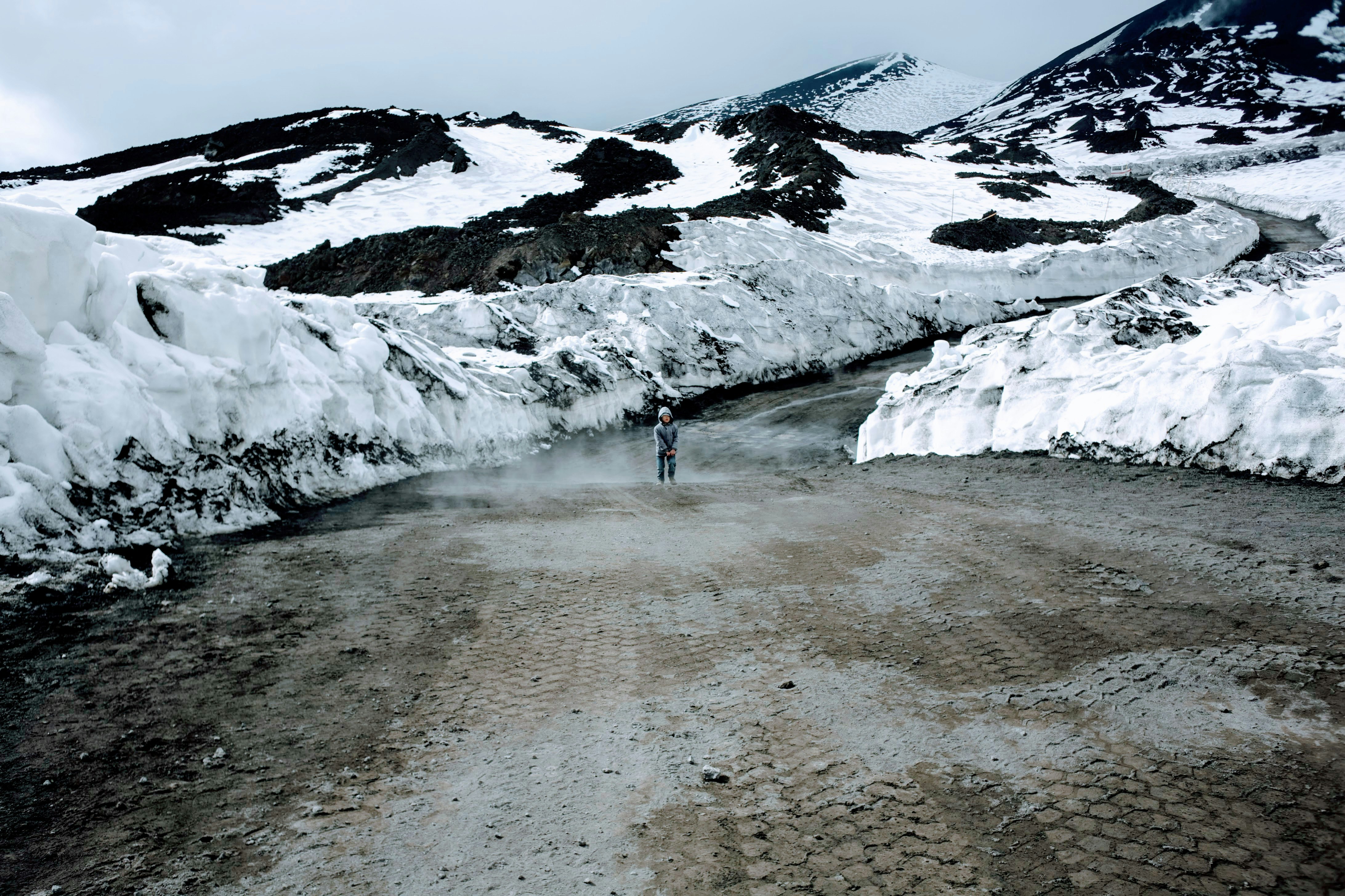 person standing near snow caps mountain